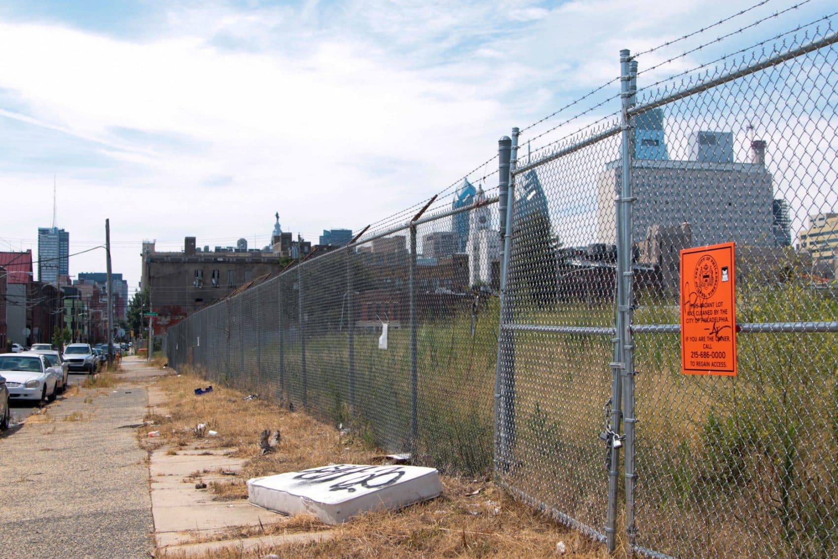 A fenced vacant lot on 13th Street in North Philadelphia. (Dean Russell/Here & Now)