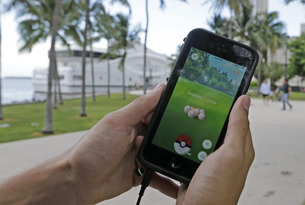 Exeggcute, a Pokemon, is found by a  Pokemon Go player, Tuesday, July 12, 2016, at Bayfront Park in downtown Miami. The &quot;Pokemon Go&quot; craze has sent legions of players hiking around cities and battling with &quot;pocket monsters&quot; on their smartphones. It marks a turning point for augmented reality, or technology that superimposes a digital facade on the real world. (Alan Diaz/AP)