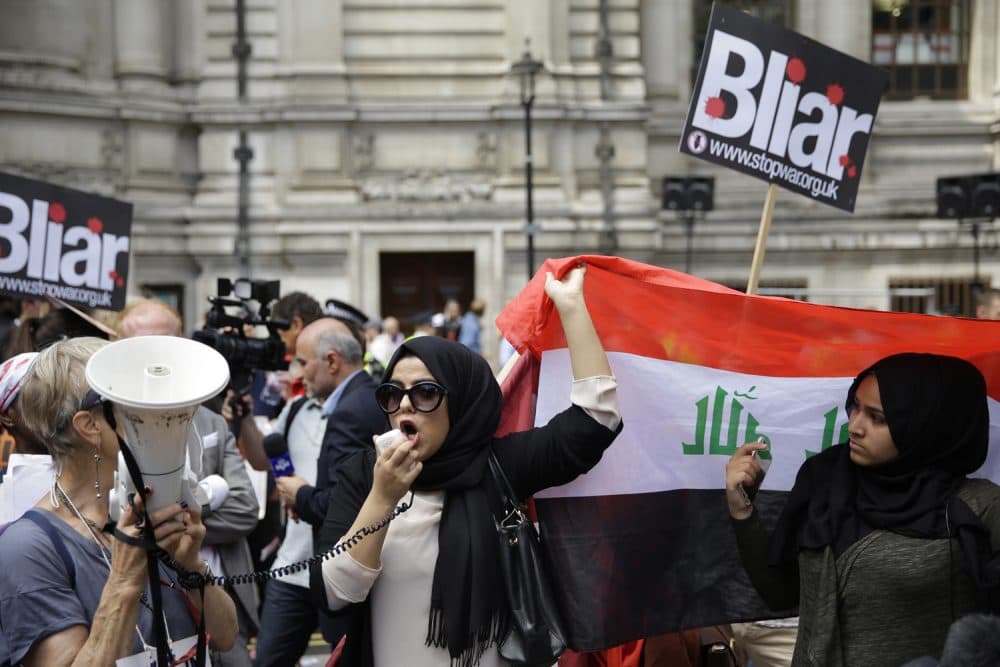A British Iraqi protester holds up an Iraqi flag, during a protest, outside the Queen Elizabeth II Conference Centre in London, after the publication of the Chilcot report into the Iraq War. (Matt Dunham/AP)