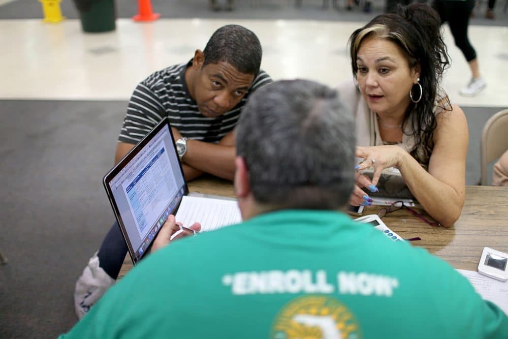 Jose Ramirez (L) and Mariana Silva speak with Yosmay Valdivia, an agent from Sunshine Life and Health Advisors, as they discuss plans available from the Affordable Care Act at a store setup in the Mall of the Americas on December 15, 2014 in Miami, Florida. ( Joe Raedle/Getty Images)