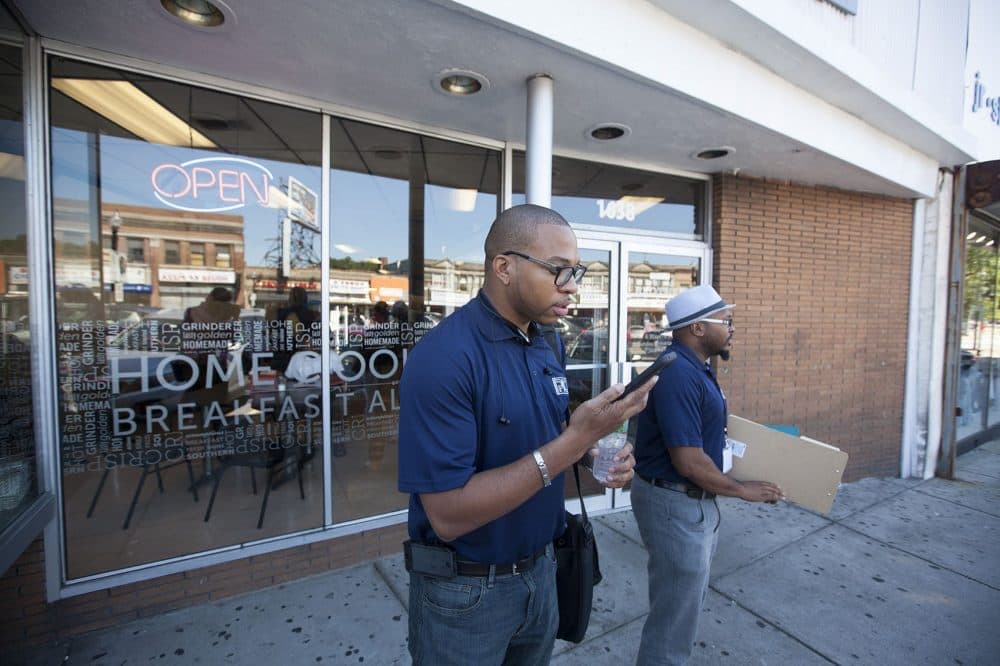 Manny Allen, manager of the Boston Public Schools reengagement center, left, and Rajon Brooks, an outreach manager with the center, begin their day of engaging with chronically absent students at Brothers Deli in Mattapan. (Joe Difazio/WBUR)