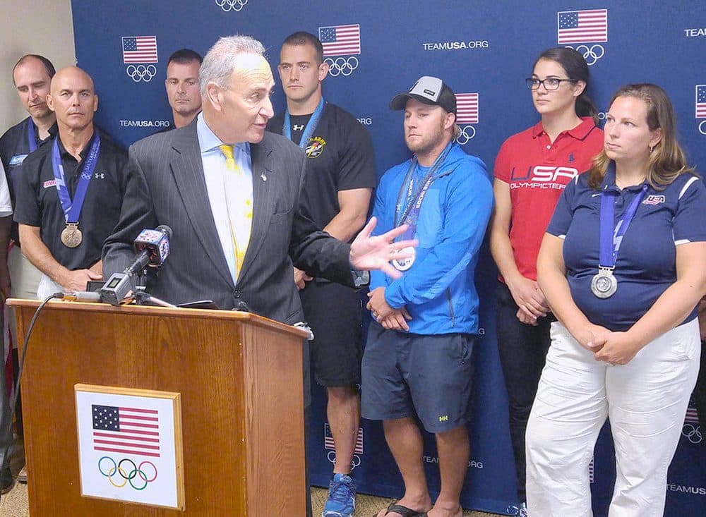 Sen. Chuck Schumer (D-NY) at the podium speaking about his campaign against Olympic medal taxes in Lake Placid, New York. (Brian Mann/NCPR)