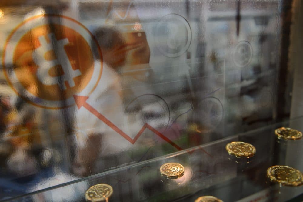 A man walks past a display cabinet containing models of Bitcoins in Hong Kong on Aug. 3, 2016. (Anthony Wallace/AFP/Getty Images)