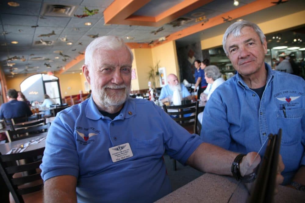 Mac McClure (left) flew more than 800 blood missions for Flights for Life. Volunteer pilots with the group help supply remote hospitals with blood every day. McClure died Tuesday in a plane crash. Ray Reher is also pictured here. (Stina Sieg/KJZZ)