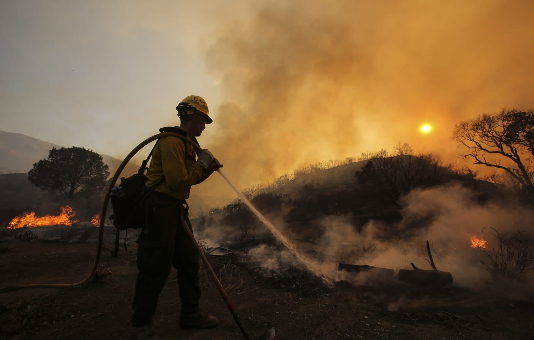 A firefighter battles a wildfire near Placerita Canyon Road in Santa Clarita, California, Sunday, July 24, 2016. (Ringo H.W. Chiu/AP)