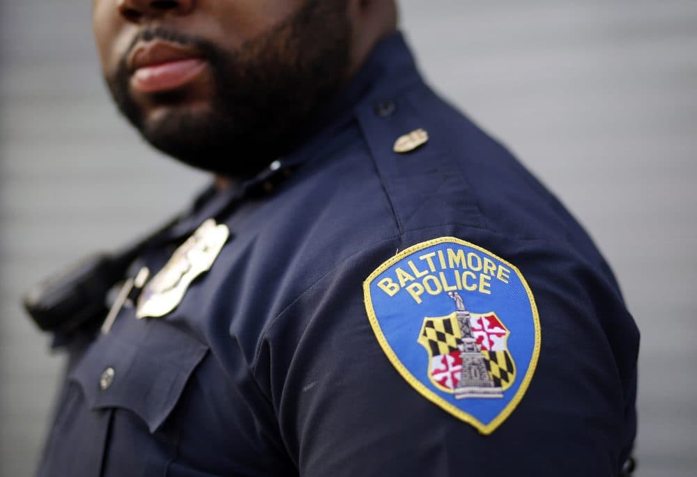 In this March 31, 2016, file photo, Baltimore Police Department Officer Jordan Distance stands on a street corner during a foot patrol in Baltimore. Baltimore police officers routinely discriminate against blacks, repeatedly use excessive force and are not adequately held accountable for misconduct, according to a harshly critical Justice Department report being presented Wednesday, Aug. 10, 2016. (Patrick Semansky/AP)