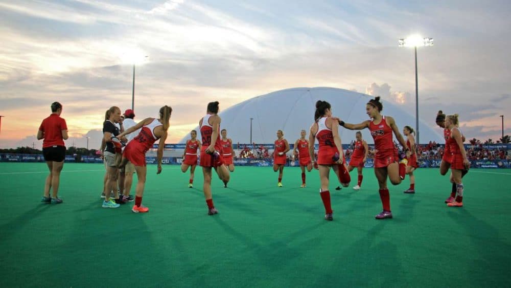 Olympic field hockey players stretch on the turf field at Spooky Nook in Manheim, Pennsylvania. (Emma Lee/WHYY)