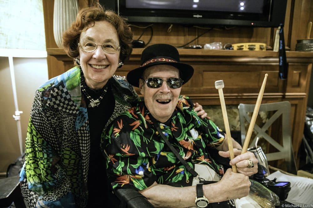 Tony Swartz-Lloyd, 79, started learning how to play the drums at 74. He'd been living with Parkinson's disease for 12 years and sought out a drumming group at Beth Israel Deaconess Medical Center for people with the disease. Here, he poses for a photo with his wife, Marilyn. (Courtesy Michael J. Lutch)