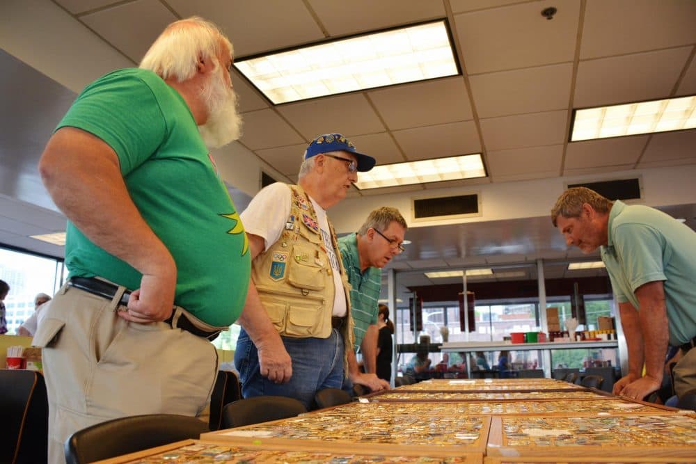 Randy Parsons (front) speaks with other Olympic pin traders at the monthly pin show in Atlanta. The event has been happening at the Varsity drive-in since the 1996 Olympics. (Sam Whitehead/GPB)