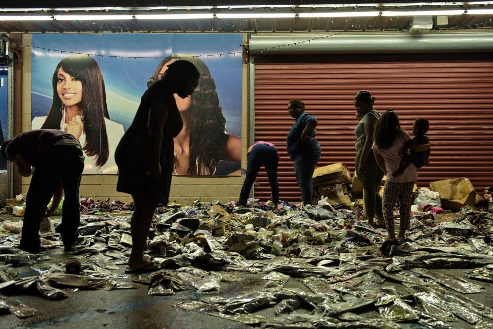 People sort through water damaged products outside Jasmine's Beauty Supply following the floods on Aug. 16, 2016 in Baton Rouge, Louisiana. (Brendan Smialowski/AFP/Getty Images)