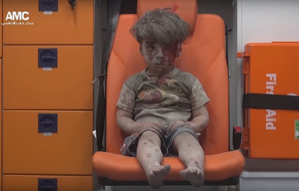 A 5-year-old boy, identified in news reports as Omran Daqneesh, sits in an ambulance Wednesday after an airstrike in Aleppo, Syria. (Aleppo Media Center)