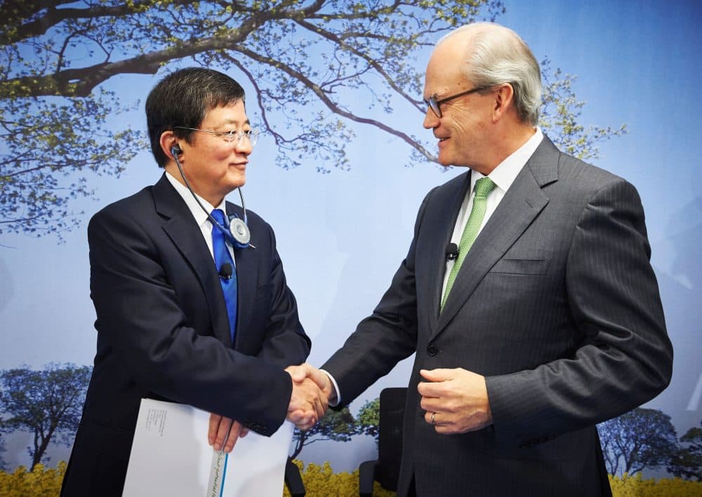 Chairman of Swiss farm chemicals giant Syngenta, Michel Demare shakes hands with Chairman of ChemChina Ren Jianxin during a press conference on Feb. 3, 2016. (Michael Buholzer/AFP/Getty Images)