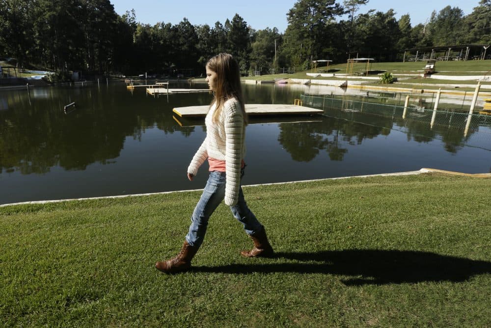 Kali Hardig, 12, survivor of a rare brain infection that is almost always fatal, walks past a lake at Willow Springs Water Park near Little Rock, Ark., Monday, Oct. 7, 2013. (Danny Johnston/AP)