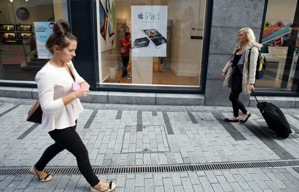 People walk past a computer shop selling Apple products in Cork, Ireland on Oct. 2, 2014. (Paul Faith/AFP/Getty Images)