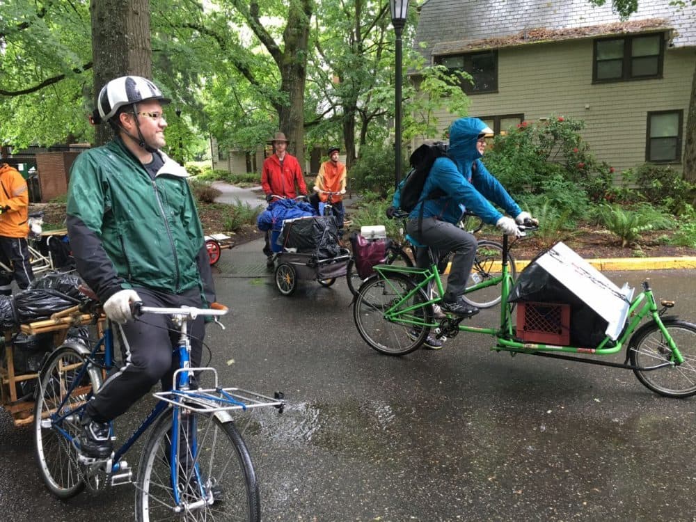 Volunteers move the belongings of Nate Martin, a graduate of Reed College, by bike to an apartment in northeast Oregon ten miles away. (Jill Ryan/Here & Now)