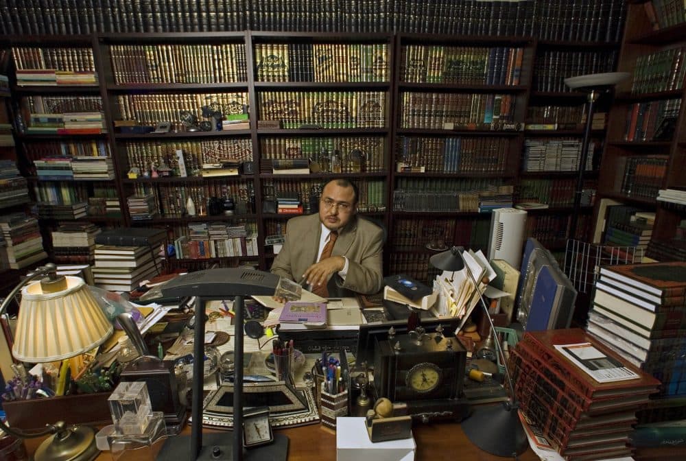 Islamic jurist professor Khaled Abou El Fadl, one of the world's preeminent Islamic scholars, holds a copy of the Qur'an in 2005 at his library in Los Angeles. (Damian Dovarganes/AP)