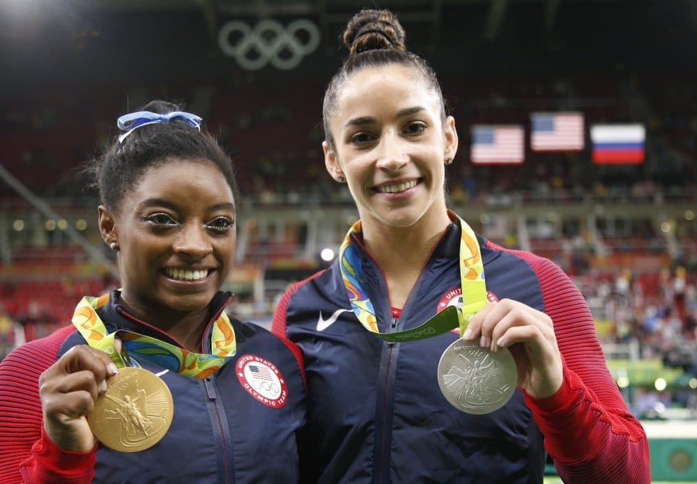 Aly Raisman (right) stands with teammate Simone Biles (left) after they won the silver and gold medals, respectively, for the women's gymnastics individual all-around at the 2016 Summer Olympics in Rio. (Dmitri Lovetsky/AP)