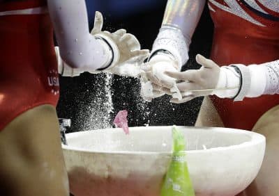 Competitors in the women's U.S. Olympic gymnastics trials put chalk on their hands for the uneven bars in San Jose, Calif., Sunday, July 10, 2016. (Gregory Bull/AP)