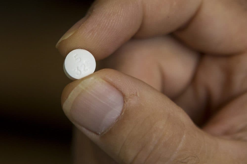 Steve Brown holds one of the Percocet pills his daughter was prescribed. (Jesse Costa/WBUR)