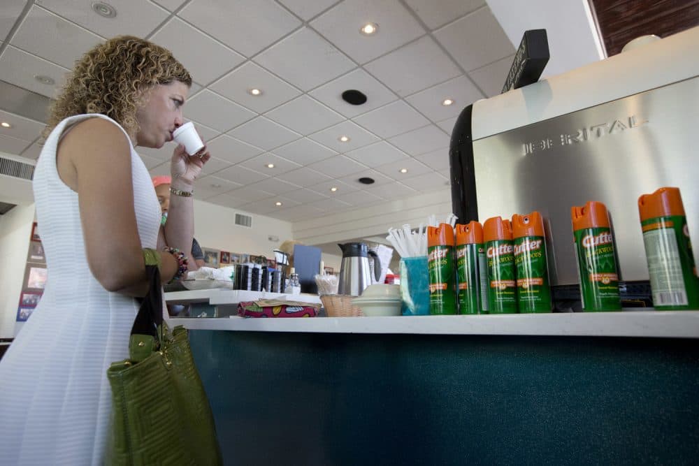 U.S. Rep. Debbie Wasserman Schultz, sips Cuban coffee next to a counter with cans of insect repellent after holding a news conference at David's Cafe Cafecito, Monday, Aug. 22, 2016, in Miami Beach, Fla. (Wilfredo Lee/AP)