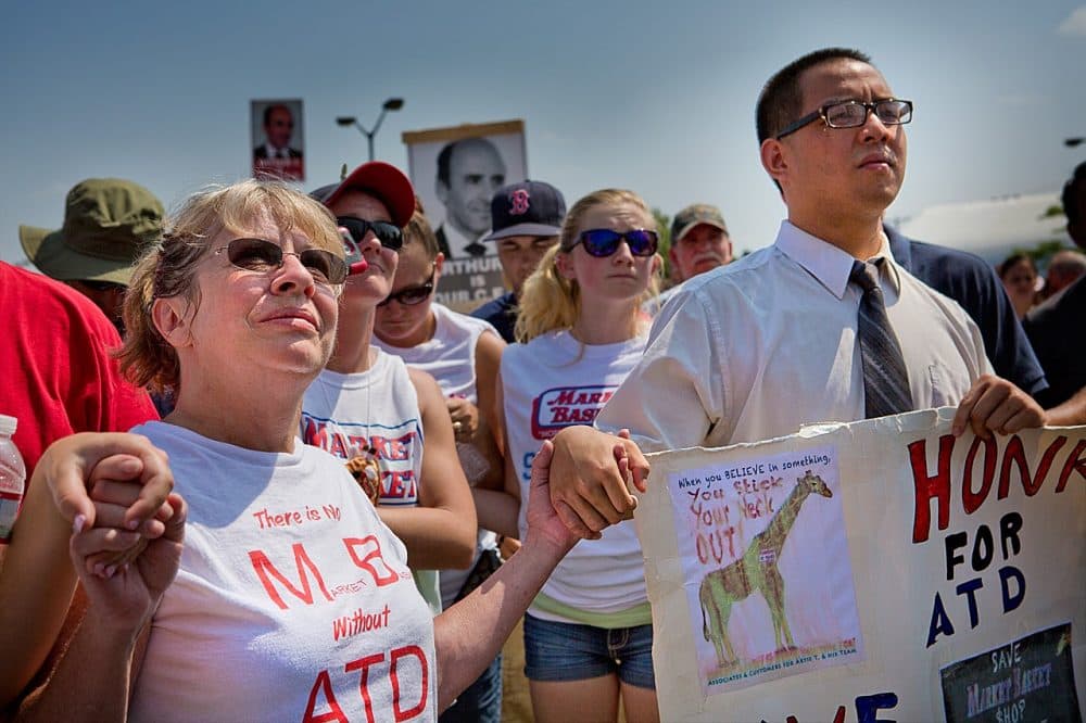 Protesters hold hands in solidarity as they rally in support of ousted Market Basket CEO Arthur T. Demoulas in Tewksbury on August 5, 2014. (Jesse Costa/WBUR)