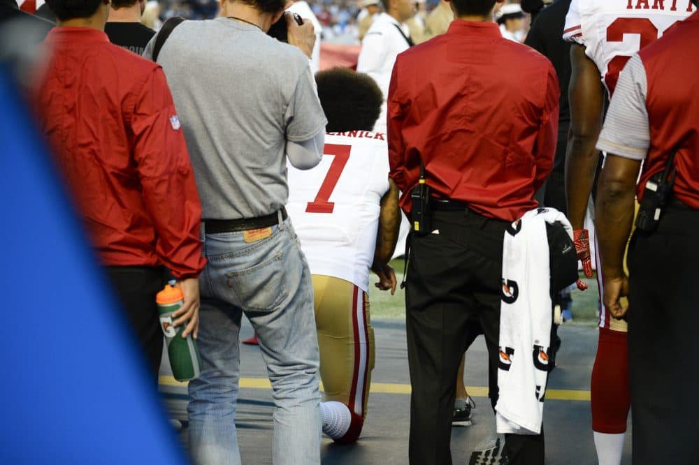 San Francisco 49ers quarterback Colin Kaepernick, middle, kneels during the national anthem on Thursday night. (Denis Poroy/AP)