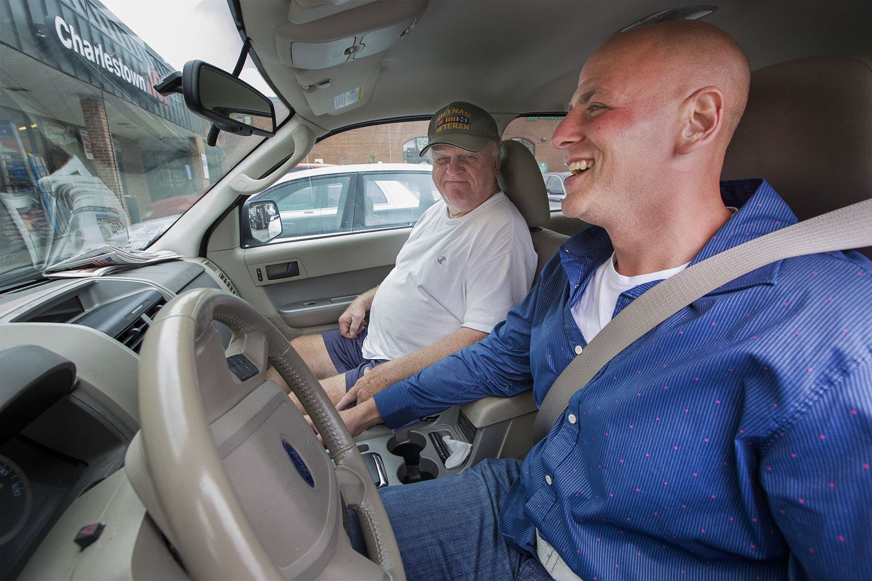 In the parking lot of the Bunker Hill Shopping Mall, Joe Donovan gets a driving lesson from his father, Joe Sr. Joe had never gotten his license before he was incarcerated. (Jesse Costa/WBUR)