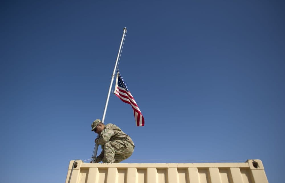 U.S. Army staff sergeant Chris Leota of Task Force 3-66 Bravo Company 172nd Infantry Brigade lowers the U.S. flag at Forward Operating Base Kushamond in Afghanistan on Sept. 11, 2011. (Johannes Eisele/AFP/Getty Images)