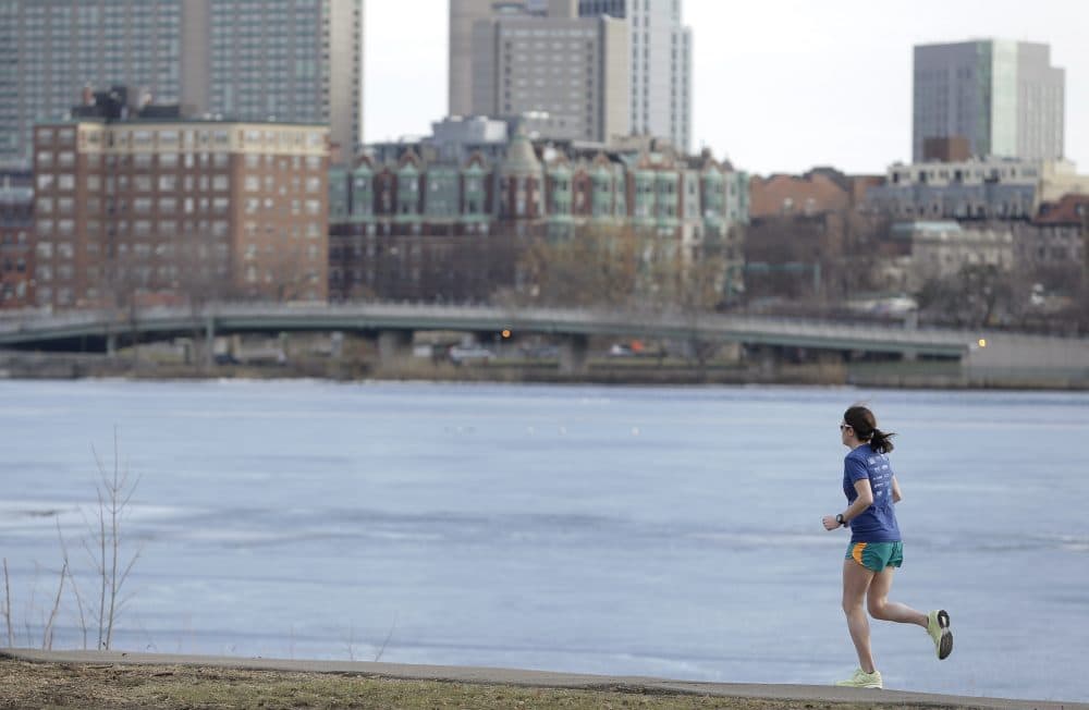 A runner makes her way along a path next to the Charles River Monday, Feb. 1, 2016, in Cambridge, Mass. (Steven Senne/AP)