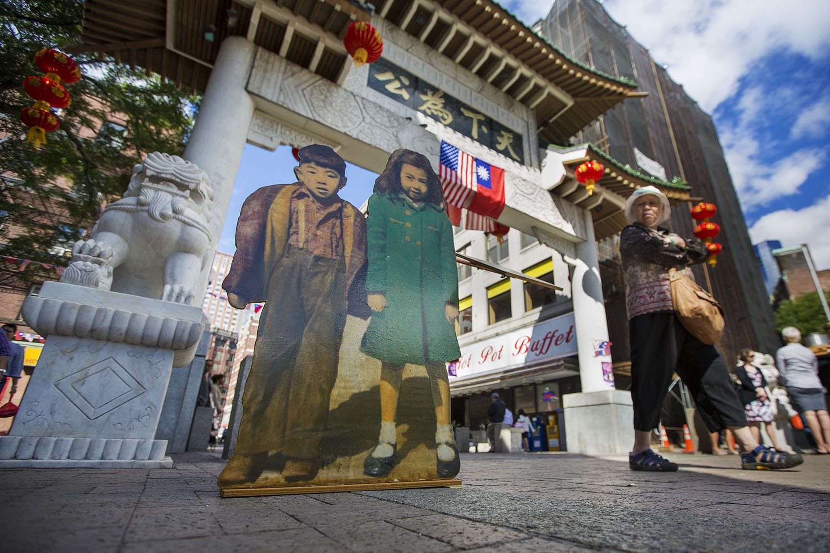 &quot;Two Kids&quot; stand at the Chinatown Gate as part of artist Wen-Ti Tsen's &quot;Home Town&quot; installation. (Jesse Costa/WBUR)