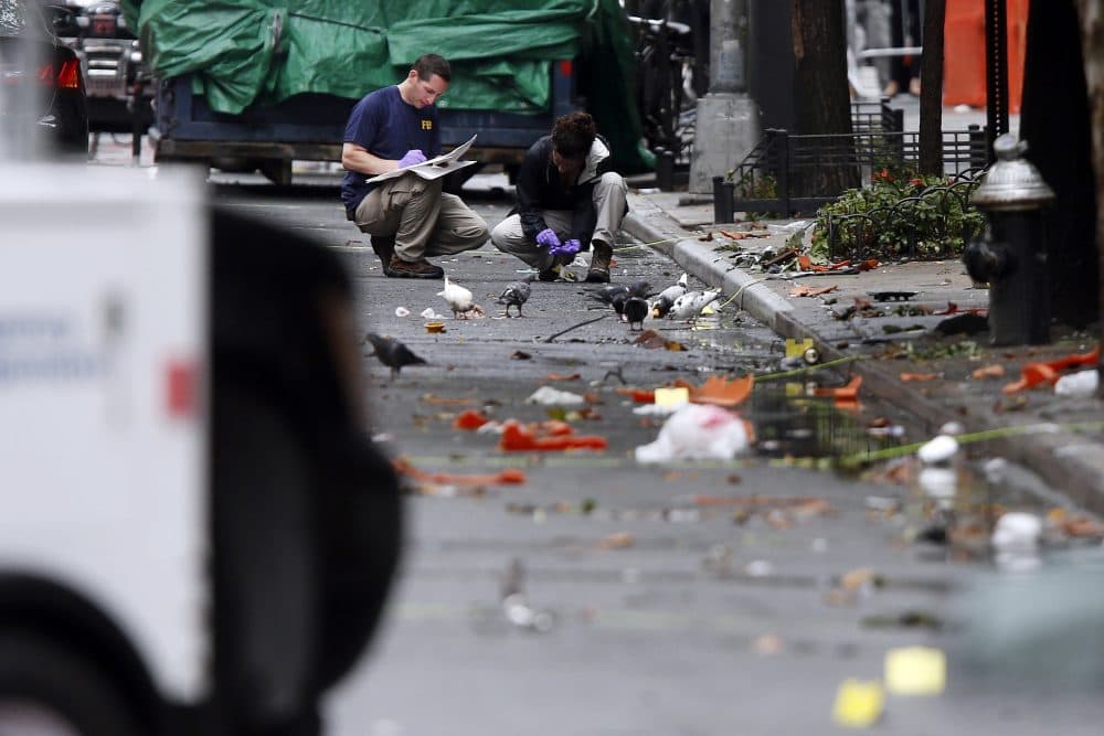 Evidence teams investigate at the scene of Saturday's explosion on West 23rd Street in Manhattan's Chelsea neighborhood, Monday, Sept. 19, 2016, in New York. Ahmad Khan Rahami, wanted in the bombings that rocked Chelsea and a New Jersey shore town was captured Monday after being wounded in a gun battle with police that erupted when he was discovered sleeping in a bar doorway, authorities said. (Jason DeCrow/AP)