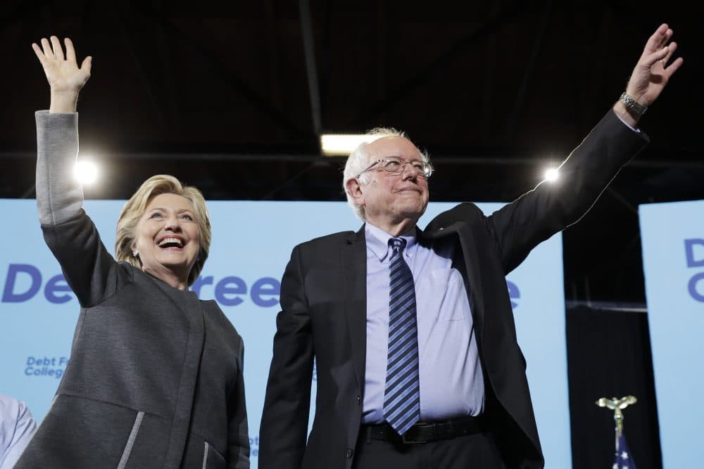 Democratic presidential candidate Hillary Clinton and Sen. Bernie Sanders, I-Vt., take the stage during a campaign stop at the University Of New Hampshire in Durham on Wednesday. (Matt Rourke/AP)
