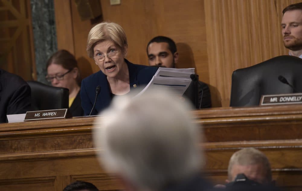 Senate Banking Committee member Elizabeth Warren holds up transcripts of earnings calls as she questions Wells Fargo CEO John Stumpf on Capitol Hill Tuesday. (Susan Walsh/AP)