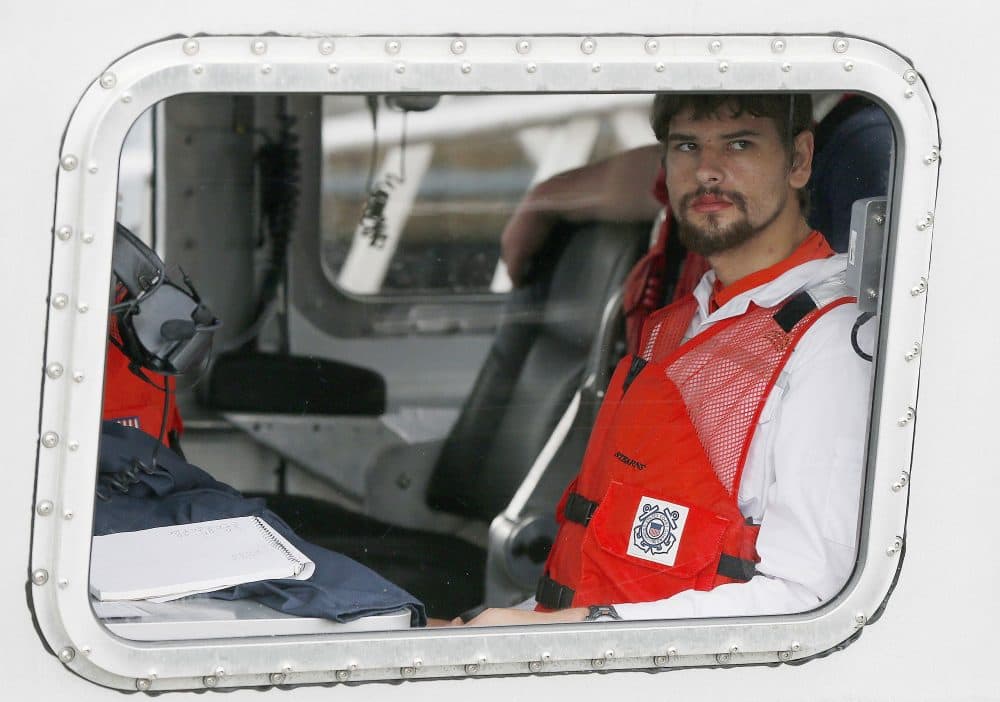 Nathan Carman arrives in a boat at the U.S. Coast Guard station in Boston Tuesday. Carman spent a week at sea in a life raft before being rescued by a passing freighter. (Michael Dwyer/AP)