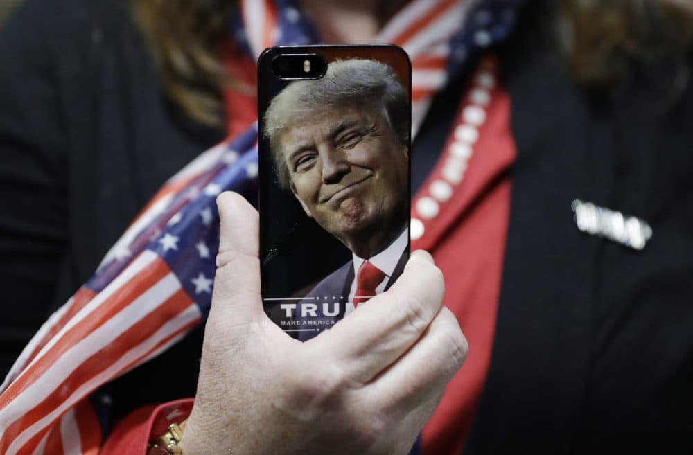 A woman holds up her cell phone before a rally with Republican presidential candidate Donald Trump, in Bedford, New Hampshire. (John Locher/AP)
