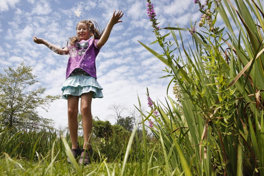 Yalena Leuliette, 7, of Greenbelt, Md., throws seeds from a cattail plant up in the air as she plays while visiting the Kenilworth Aquatic Gardens in northeast Washington, on Sunday, Aug. 9, 2015. Leuliette visits the public garden with her parents a few times a year. (Jacquelyn Martin/AP)