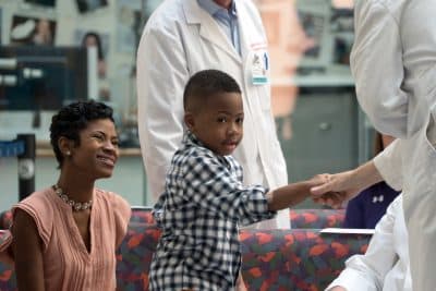 Zion Harvey, center, who received a double hand transplant in July 2015, shakes hands with a health care worker as his mother Pattie Ray, left, smiles during a news conference, Tuesday, Aug. 23, 2016 at The Children's Hospital of Philadelphia in Philadelphia. (Dake Kang/AP)