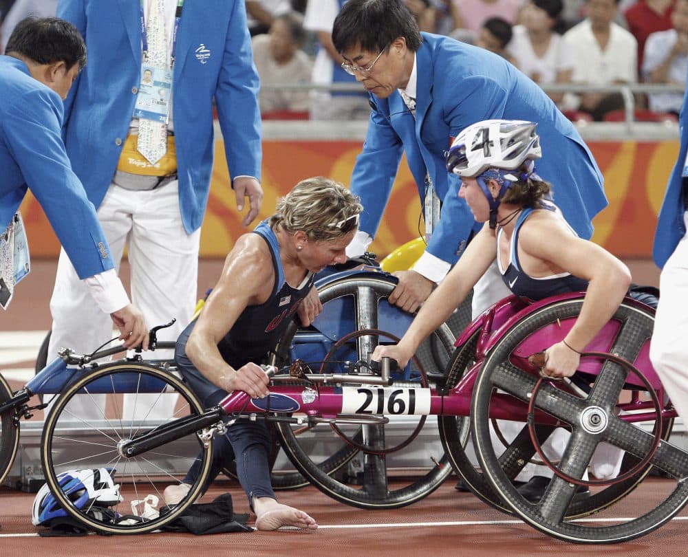 American Cheri Blauwet, center, is helped by officials while her teammate Amanda McGrory looks on after they crashed on the last lap of the Women's 5,000 meter T54 final during the Beijing Paralympic Games, Sept. 8, 2008. (AP Photo/Andy Wong)