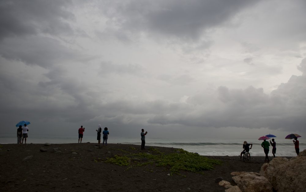 People watches the clouds and the sea in the outskirts of Kingston, Jamaica, Sunday, Oct. 2, 2016. (Eduardo Verdugo/AP)