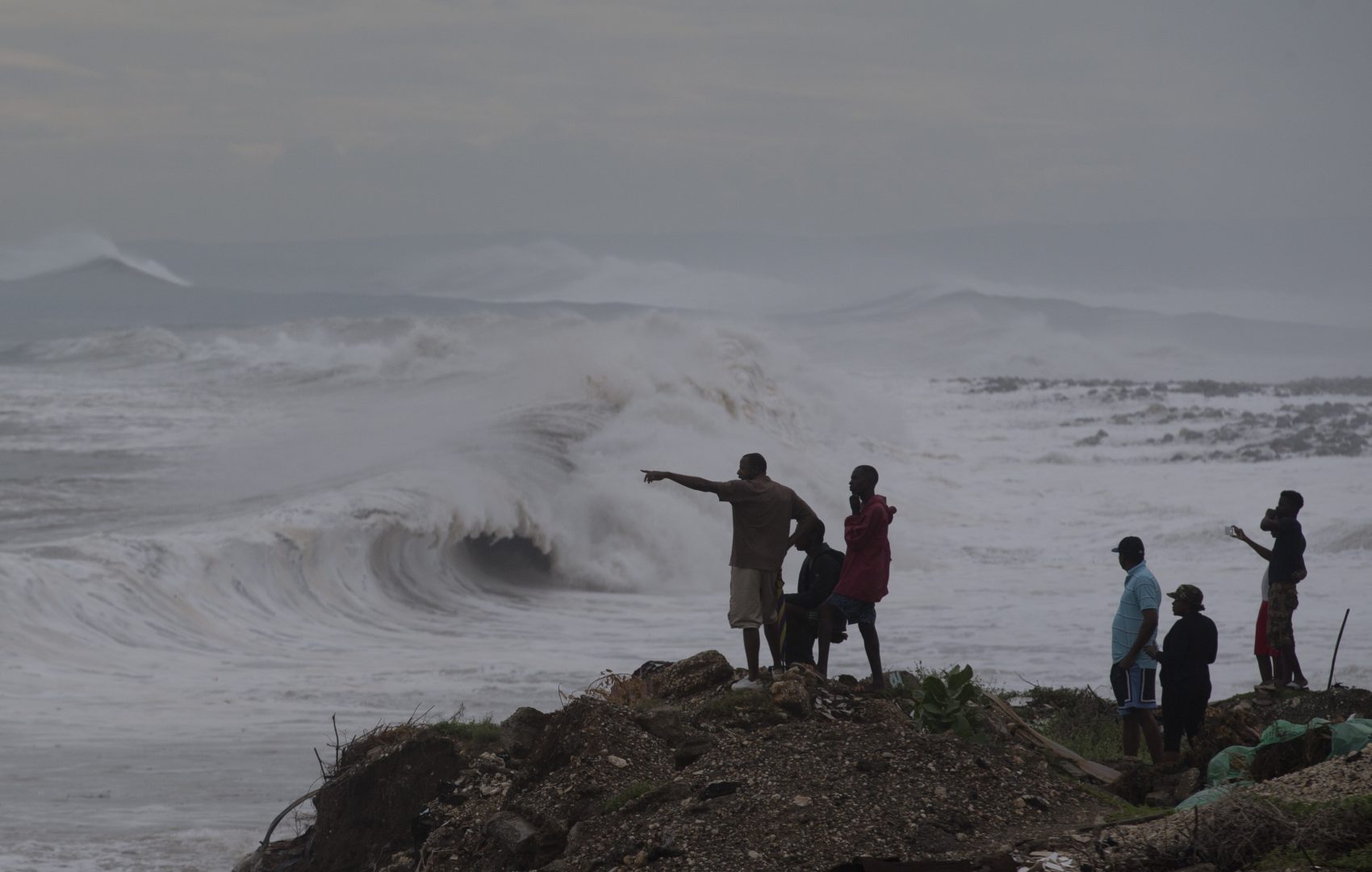 People stand on the coast watching the surf produced by Hurricane Matthew, on the outskirts of Kingston, Jamaica on Monday. (Eduardo Verdugo/AP)