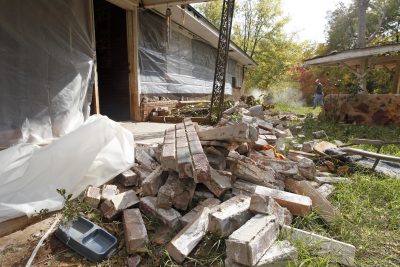 This Nov. 6, 2011 file photo, Chad Devereaux works to clear up bricks that fell from three sides of his in-laws' home in Sparks, Okla, after two earthquakes hit the area in less than 24 hours. (Sue Ogrocki/AP)