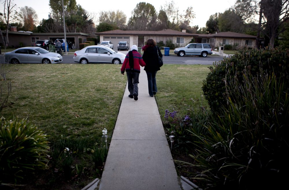 In this photo taken Dec. 22 2011, Evelyn Volk, right, walks with her mother Maria Koenig, who suffers from dementia, as they leave home for grocery shopping in the Woodland Hills section of Los Angeles. (Jae C. Hong/AP)