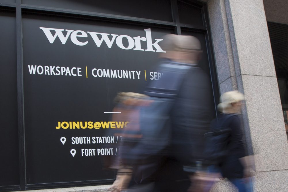 People walk by the office of WeWork at South Station on Beach Street. (Jesse Costa/WBUR)