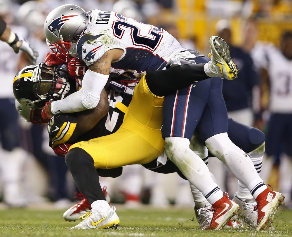 Pittsburgh Steelers running back Le'Veon Bell (26) is tackled by New England Patriots strong safety Patrick Chung (23) during the second half of Sunday's game. (Jared Wickerham/AP)