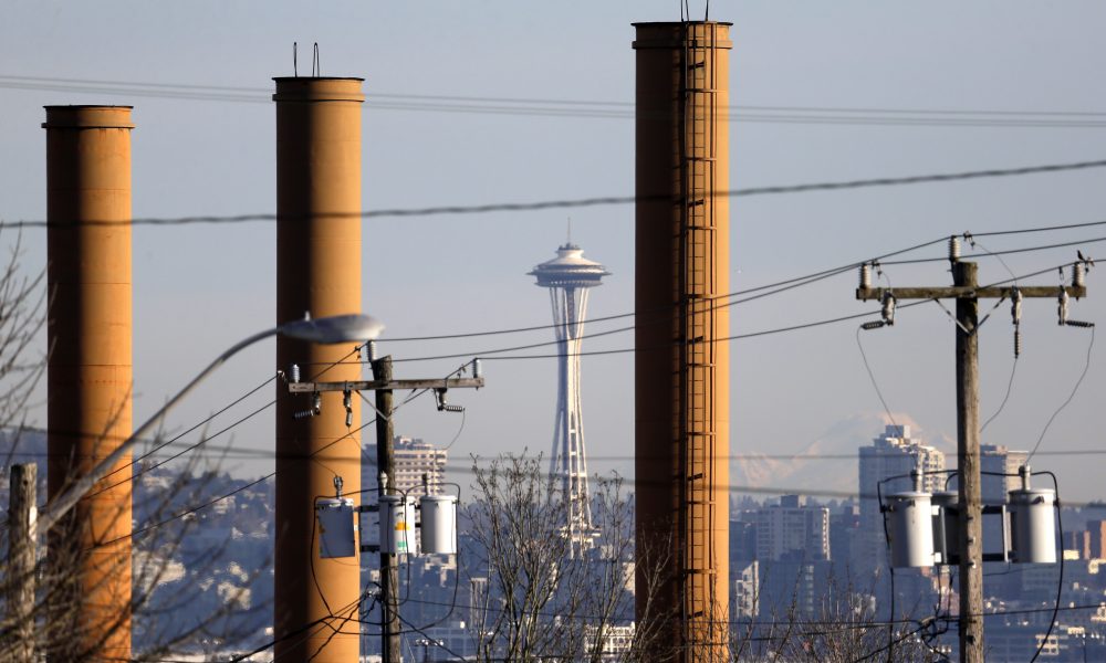 In this Thursday, Feb. 25, 2016 photo, the Space Needle is seen in view of still standing but now defunct stacks at the Nucor Steel plant in Seattle. The plant is among those likely to be affected if Washington state becomes the first in the nation to pass a tax on carbon pollution from fossil fuels such as coal, gasoline and natural gas. (Elaine Thompson/AP)