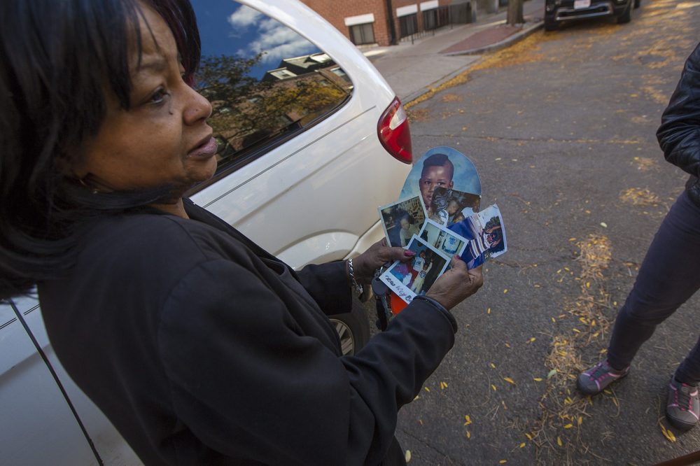 Hope Coleman holds old photos of her son Terrence, who was fatally shot by Boston police on Sunday morning. (Jesse Costa/WBUR)