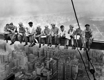 Construction workers eat their lunches atop a steel beam 800 feet above ground, at the building site of the RCA Building in Rockefeller Center. (daily sunny/Flickr)