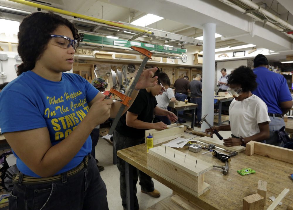 From left: Students Naomi Apatano, Sylvia Glezelis and Alyssa Mills work on their miter boxes during a training session conducted by Nontraditional Employment for Women, to train women for employment in the construction trades, in New York, on Aug. 18, 2014. (Richard Drew/AP)
