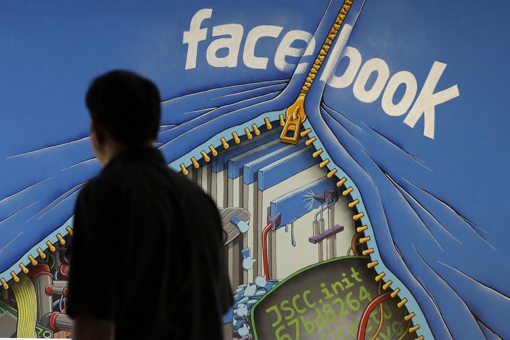 A man walks past a mural in an office on the Facebook campus in Menlo Park, Calif. (Jeff Chiu/AP)