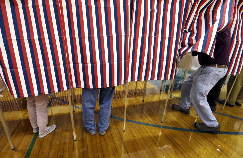 A voter enters a booth on Tuesday at a polling place in Exeter, N.H. (Elise Amendola/AP)